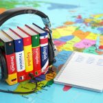 Learning languages online. Audiobooks concept. Books and headphones on the map world. 3d